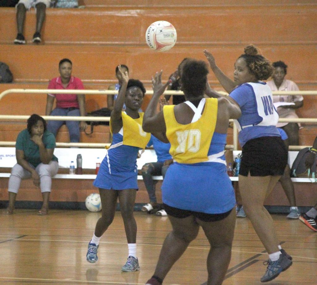 Police Youth Club's Akeilah George-Elcock, left, makes a pass to Merlicia Durham in a Court All Sectors Netball League match vs UWI recently. PHOTO BY ROGER JACOB 
