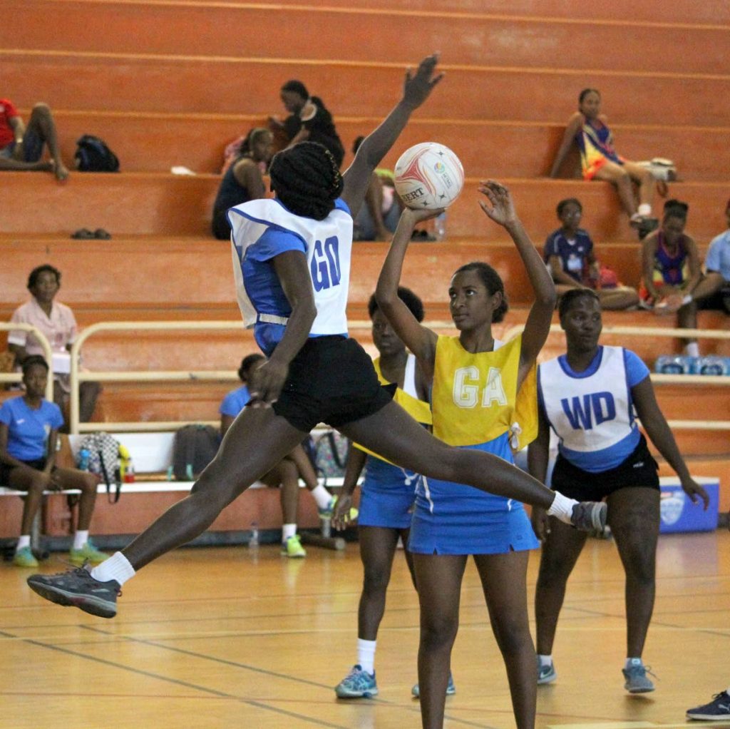 UWI Y’s Sherisse Richards,left, attempts to block the shot of Police Youth Club’s  goal attack Kaliyah Cooper, during the Courts All Sectors Netball League encounter,on Tuesday, at the Eastern Regional Indoor Sports Arena, Tacarigua.