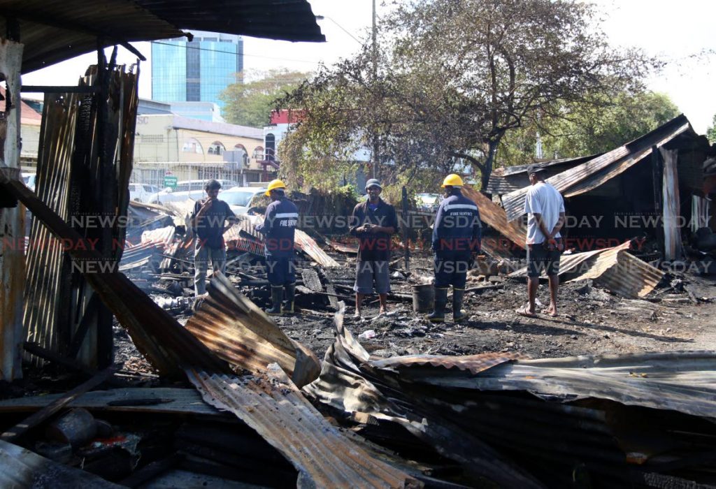 Fire Officers an the scene of a fire which destroyed the shacks of 11 fishermen  at Kings Wharf, San Fernando. PHOTO BY ANSEL JEBODH
