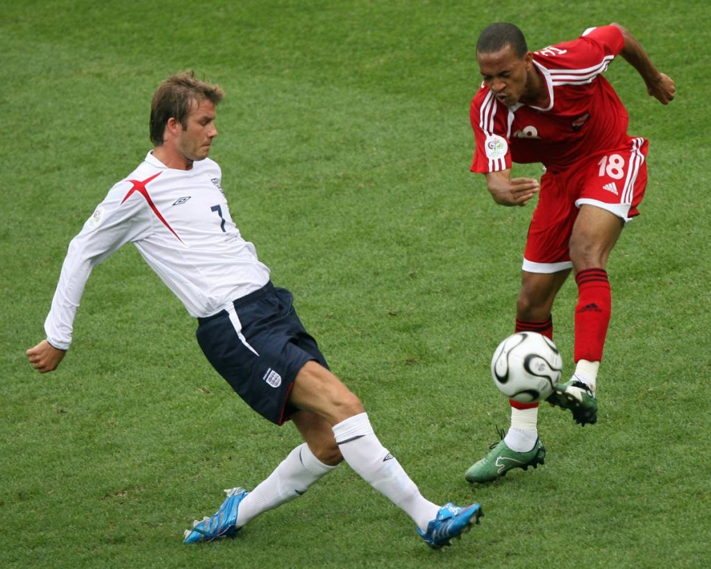 In this June 15,2006 file photo,English midfielder David Beckham (L) is challenged by TT’s midfielder Densill Theobald (R) in their opening round Group B World Cup football match at Nuremberg’s Franken Stadium.