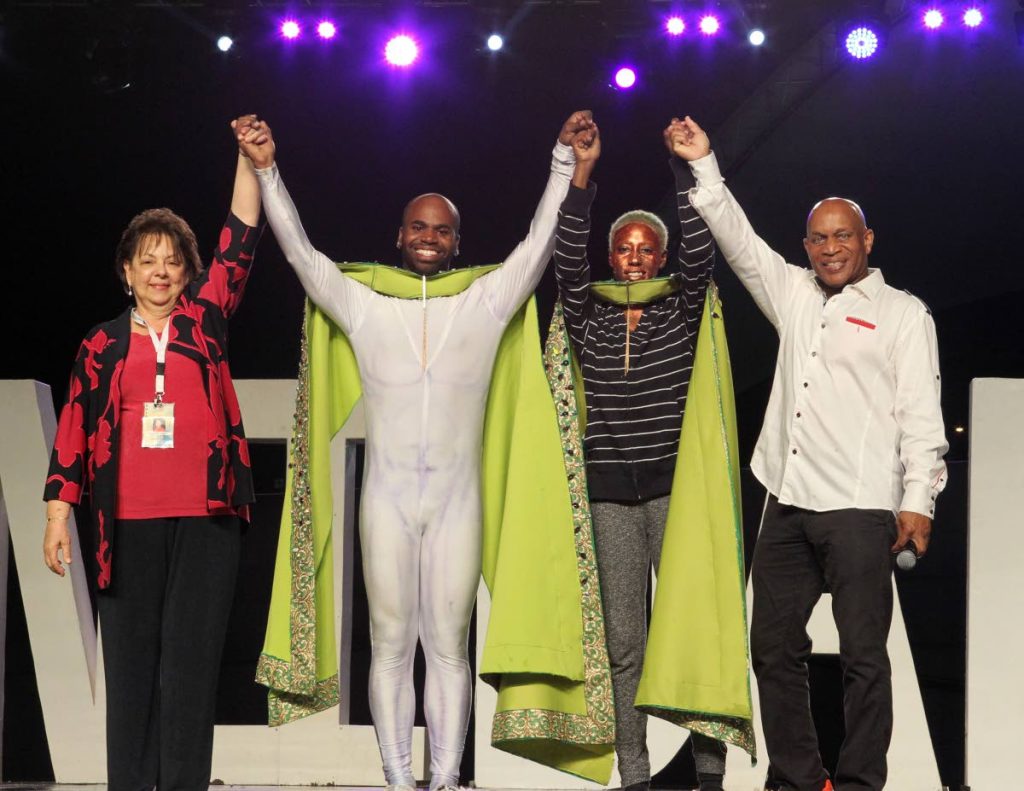 WE RULE: TT Carnival Bands Association president Rosalind Gabriel, left, and NCC CEO Colin Lucas, right, raise the hands of newly crowned King and Queen of Carnival Joseph Lewis and Shynel Brizan after the show on Wednesday.