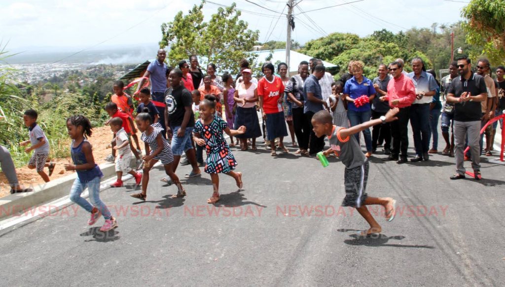 Children happily run across Laventille Road as St Ann's East MP Dr Nyan Gadsby-Dolly and Works and Transport Minister Rohan Sinanan, alongside residents and officials, cut the ribbon to open the road in Febeau Village, San Juan on Saturday. PHOTO BY SUREASH CHOLAI 