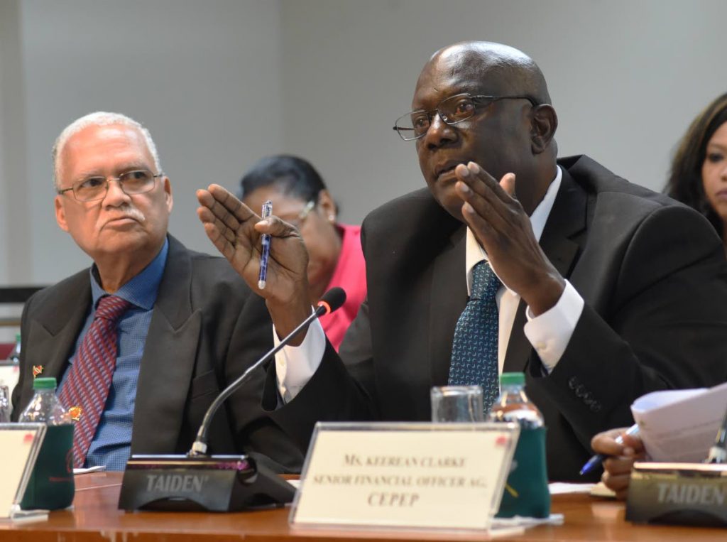 General manager of CEPEP Keith Eddy, right,  addresses members of the State Enterprises Joint Select Committee while CEPEP's chairman Ashton Ford look on at the Parliament building, International Waterfront Centre on Monday. PHOTO BY KERWIN PIERRE