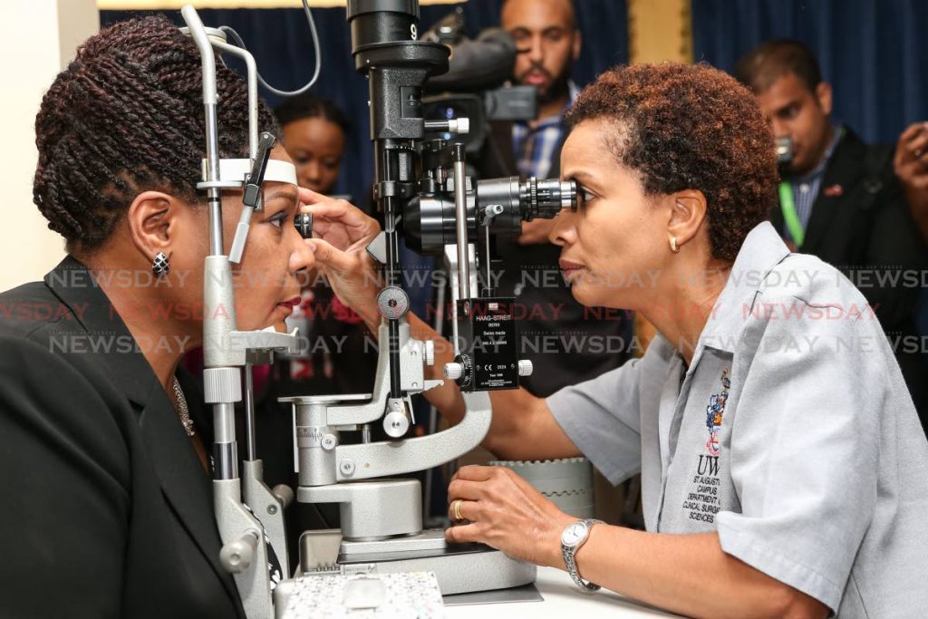 Dr. Desriee Murray conduts Slit Lamp Biomicroscopy on President Paula-Mae Weeks as part of World Glaucoma Week 2019 at the Cottage, Office of the President, St Anns. Photo by Jeff K. Mayers 