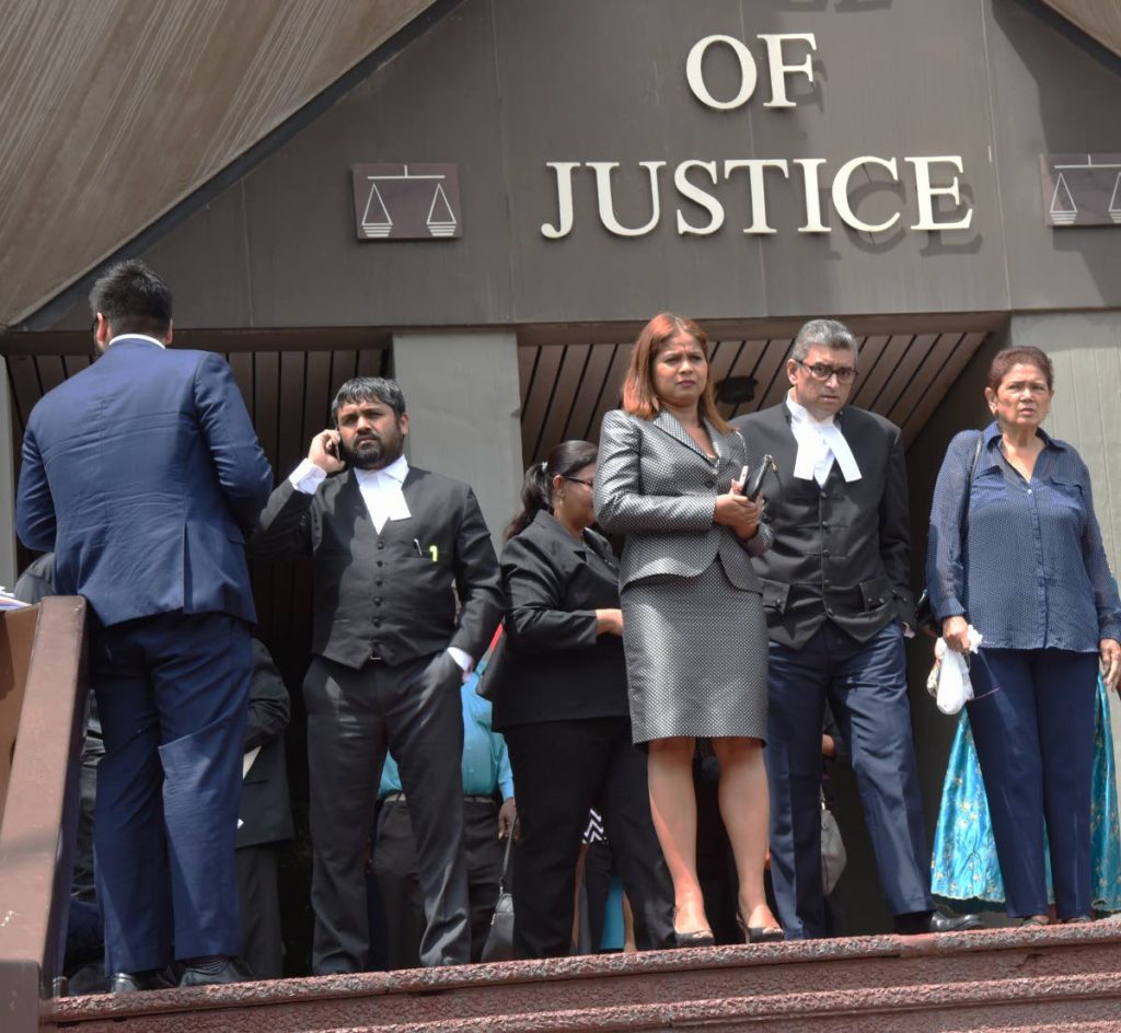 Justice Ricky Rahim, centre, leaves the Hall of Justice, Port of Spain, after fire alarms went off because of a faulty aircondition unit belt.