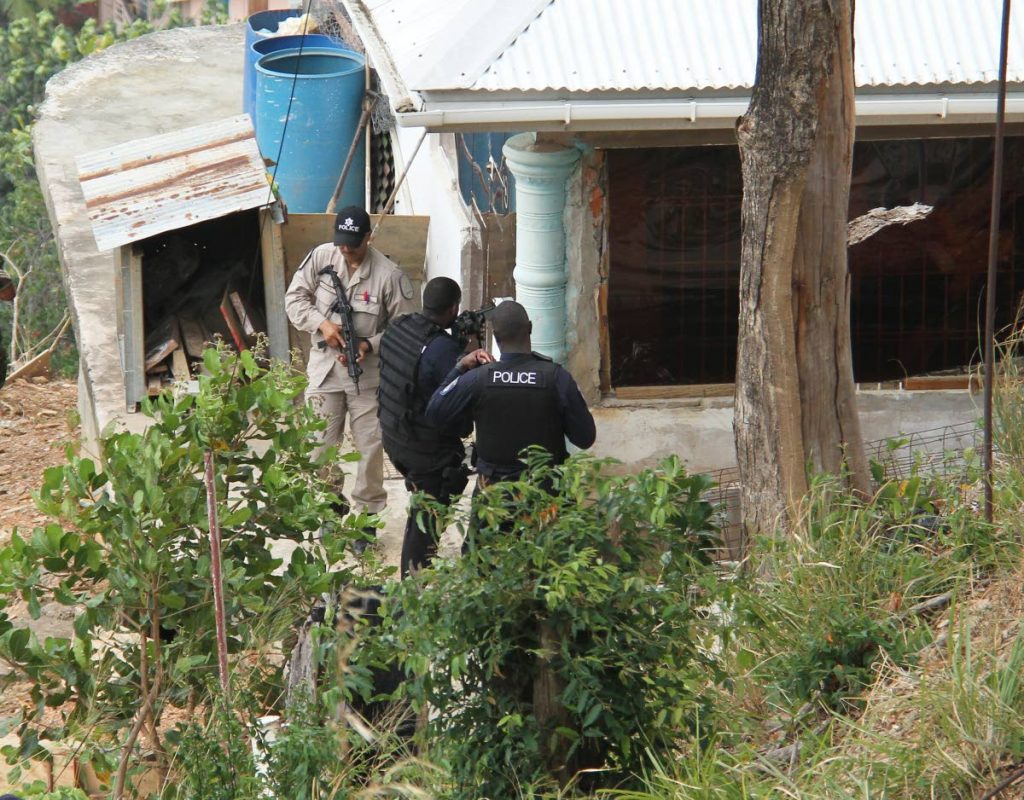 Police surround a house at Abbe Poujade Street, Carenage on Friday during a lockdown after a shootout between gangs. PHOTO BY AYANNA KINSALE