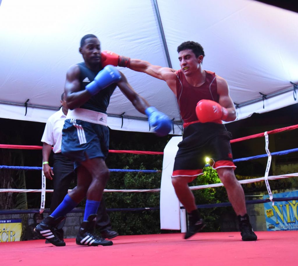 Venezuela's Eduardo Medina,right, lands a punch to the face of TT's Aaron Prince, during a 73kg class bout, on Friday night, at the Smokey and Bunty carpark, Ariapita Avenue, Woodbrook.