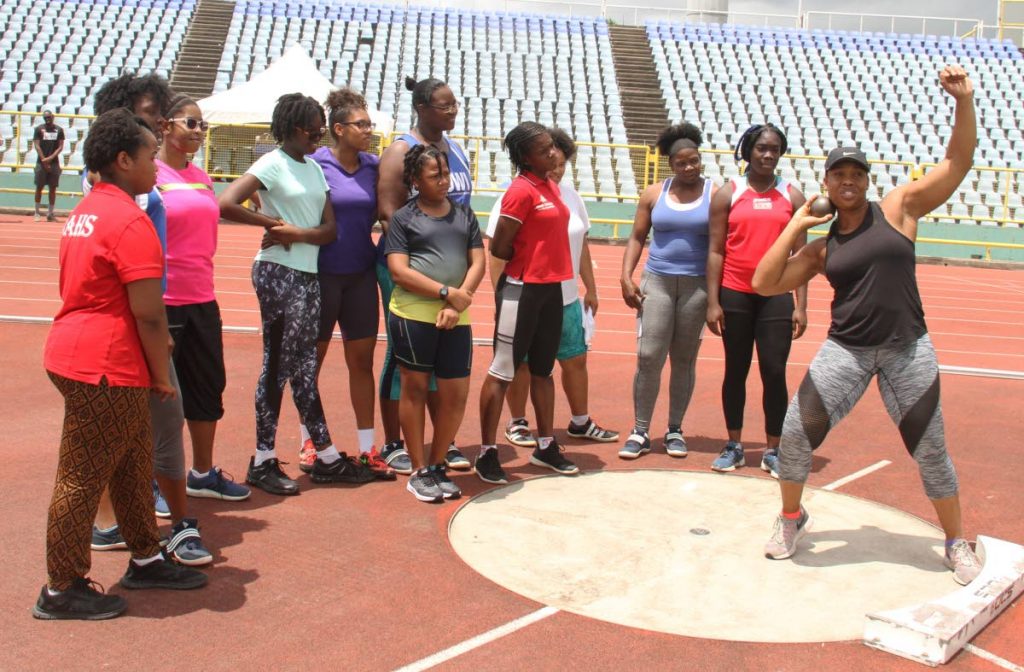 Four-time Olympian Cleopatra Borel,right, demonstrates shot put technique to participants at the Cleopatra Borel Foundation Throws Meet, yesterday, at the Hasely Crawford Stadium,Port of Spain.