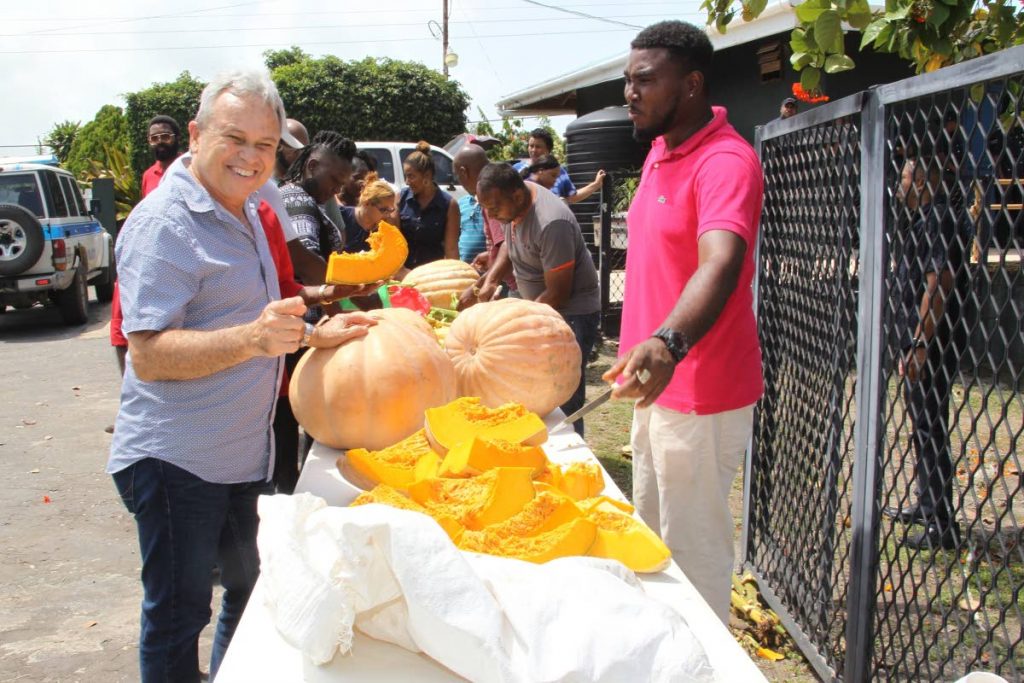 Acting Prime Minister Colm Imbert waits for a piece of pumpkin as members of the PNM general council, of which he is chairman, relax after a meeting at Hambug Hallows, Toco yesterday. PHOTOS BY ROGER JACOB