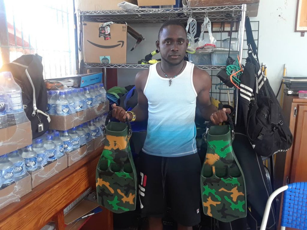 Giovanni Vidalis shows off some of the diving gear at Frontier Divers at Store Bay in Tobago.