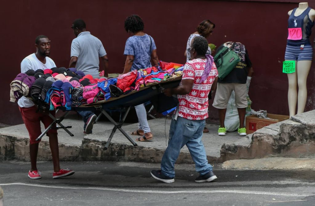 These street vendors hurry to move their items from High Street onto Short Street San Fernando as police were on foot patrol along High street to clamp down on illegal street vending in the southern capital. 

Photo: Jeff K. Mayers