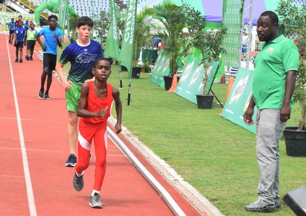 Jareem Mondezie, foreground, from Diamond Vale Govement School, looks to cross the finish line in frist place in the boys open walk 400m at the 32nd Kelvin Nancoo Primary School Milo Games,yesterday.