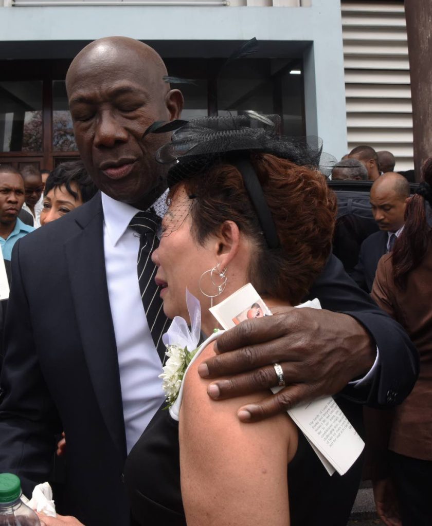 Prime Minister Dr Keith Rowley comforts Sherlyn Monteil during the funeral of her son Stefan---Flavorite Foods Ltd CEO and Yuma bandleader---at Assumption Church, Maraval on Friday. PHOTO BY KERWIN PIERRE