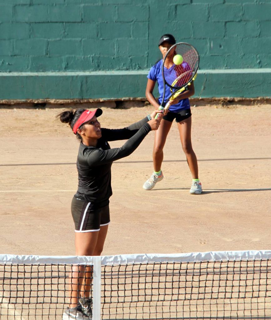 Carlista Mohammed (left) makes a return while her teammate Cameron Wong looks on during the women’s doubles final yesterday.