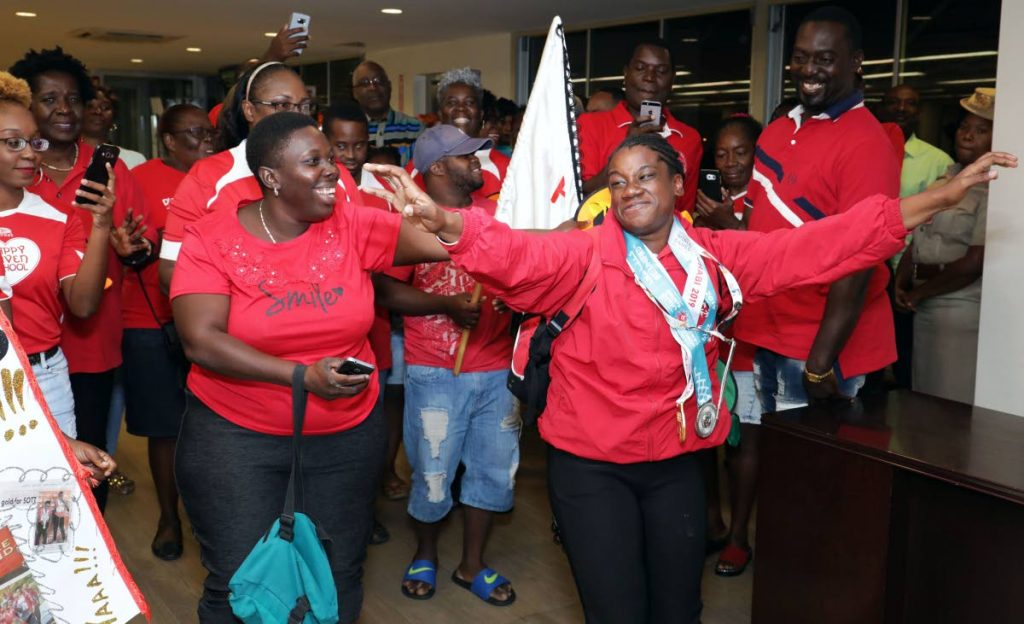 Teachers and pupils of the Happy Haven school celebrate Special Olympian Sapphire Jackson on her arrival, at a welcome reception, in the international departure lounge, of the ANR Robinson International airport, on Friday night.