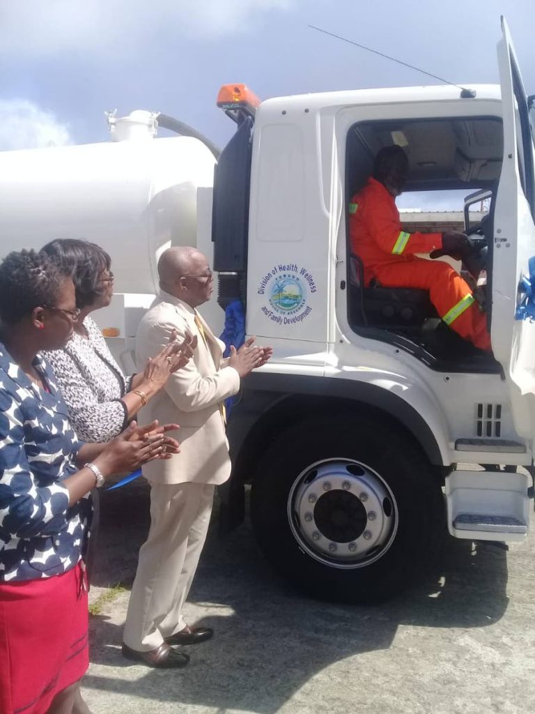 Chief Secretary Kelvin Charles and Health Secretary Agatha Carrington applaud the arrival of a new cesspool tanker to the division's fleet.   PHOTO BY COREY CONNELLY