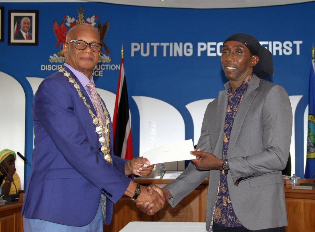 San Fernando Mayor Junia Regrello, left, presents Brian London with a prize at the San Fernando City Corporation's Carnival awards ceremony yesterday. 