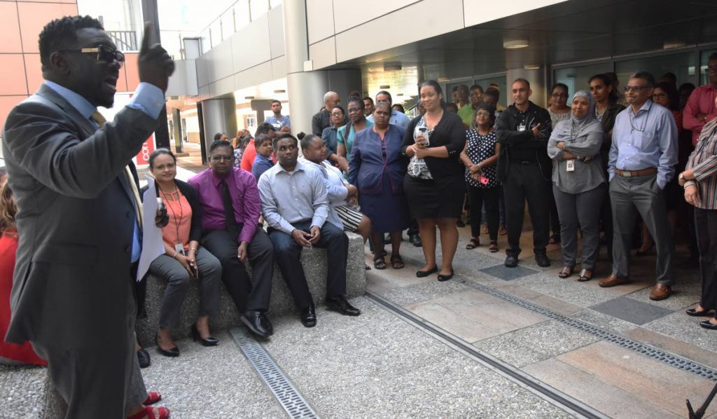 PSA President Watson Duke talks to workers from Ministry of Finance Inland Revenue Division at Govement Plaza, Richmond Street, Port of Spain, yesterday. PHOTO BY KERWIN PIERRE.