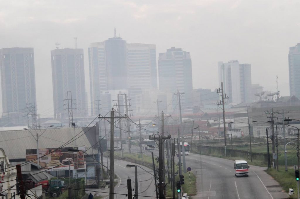 Downtown Port of Spain is covered in smoke from a fire that broke out at the Beetham landfill in 2016. The Planning Ministry has embarked on a plan to measure and reduce TT's greenhouse gas emissions in accordance with the Paris Environmental Accord. FILE PHOTO