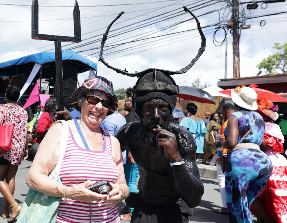 A tourist from the cruise ship Ventura poses for a photo 
with a devil mas character during the launch of 
Tobago’s 2019 in Scarborough in January.