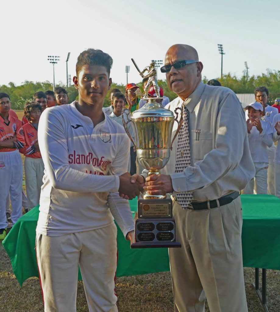 TT Under-15 player Justin Jagessar, left, collects a trophy from TT Cricket Board president Azim Bassarath, after leading the Central Zone to the U-15 Inter Zone title earlier this year. Jagessar scored 73 yesterday against Guyana in the Regional U-15 tournament. PHOTO COURTESY TTCB