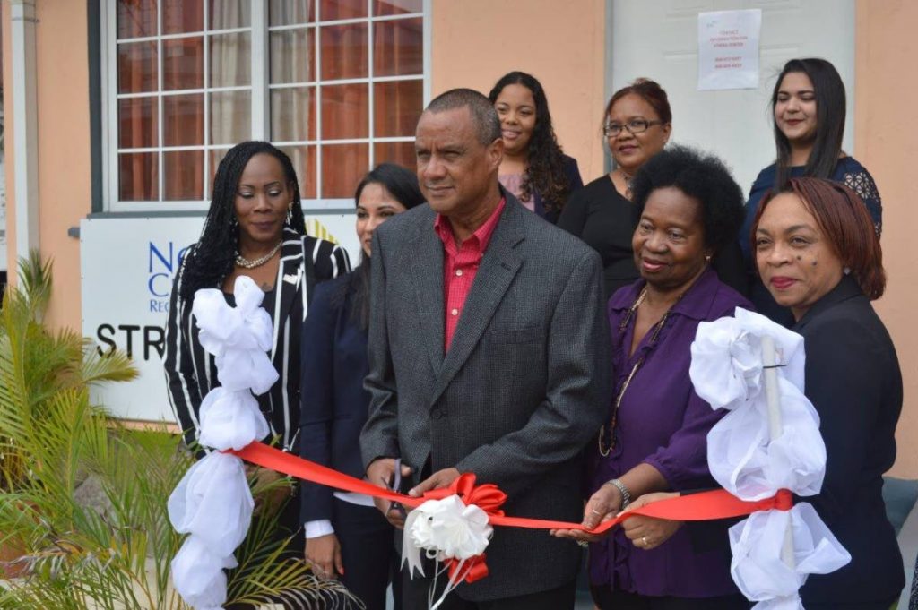 NCRHA's deputy chairman Elvin Edwards cuts the ribbon
to officially open the NCRHA's Stress Relief Centre in Chaguanas. First row from left is Renee Pilgrim, NCRHA facilities manager - Chaguanas Cluster,  Ashvini Nath, Manager - Mental Health Services at Ministry of Health, NCRHA Director Yvonne Bullen-Smith and NCRHA's chief operations officer Stacy Thomas-Lewis. Members of the clinical team in the second row are clinical psychologists' Cavelle Delfosse, Patricia Lee-Wah Cooper and Samidha Maharaj.