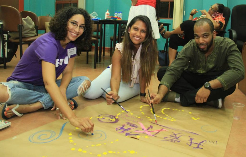 Art therapist Kristi Anatol, left, Nalini Goorahlal and Marcus Sanatan participate in an art activity at Queen's Royal College Creative Arts Therapy Week at the college, Maraval Road, Port-of-Spain on Friday. 
