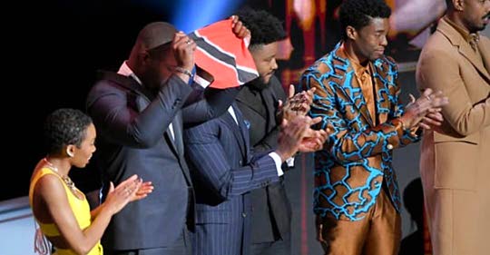TT-born actor Winston Duke waves a TT flag as he and his fellow cast members of the 2018 film Black Panther, accept the award for Outstanding Motion Picture at Saturday's NAACP Image Awards in the US.
