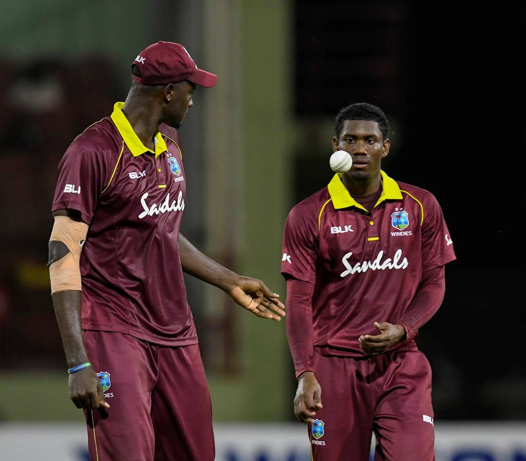 Windies captain Jason Holder, left, chats with pacer Keemo Paul, right, during a 2018 series against Bangladesh. 