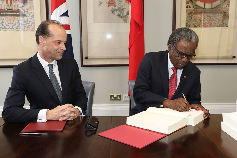 TT's High Commissioner to the UK Orville London, signs the Cariforum-UK trade agreement as Britain's Minister for Trade Policy, George Hollingbery (left), looks on. Photo courtsey the Ministry of Trade and Industry