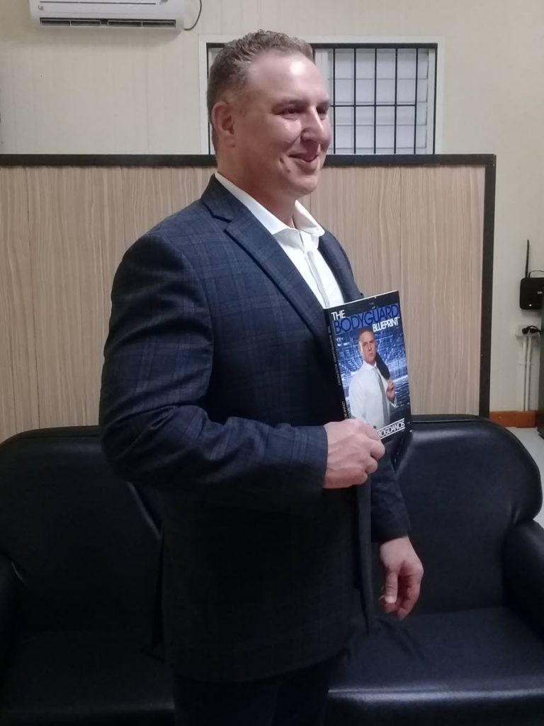 Certified protection specialist Lenny Bogdanos shows a copy of his book, The Bodyguard Blueprint, in which bodyguard Brent Eastman gives his success story.
