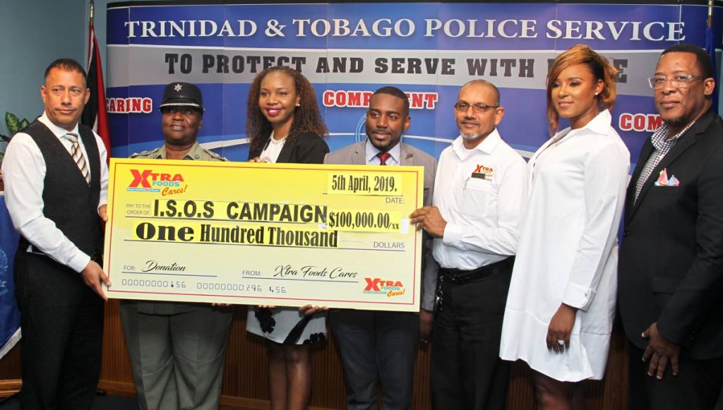 Captain Gary Griffith, Commissioner of Police symbolically receives a cheque valued at TTD$100,000.00 by (4th and 5th from left) Farook Nabbie, General Manager of Xtra Foods, Daniel Austin, Marketing Manager of Xtra Foods, alongside (2nd and 3rd from left) ACP Patsy Joseph, Head of Community Relations, Aisha Corbie, Head of Victims and Witness Support Unit, (at right) Michael Seales, President of the TTPS Social & Welfare Association and (2nd from right) Nicole Dyer-Griffith, Patron of the Police Wives Association of T&T, during the presentation ceremony at the weekly media conference, Police Administration Building, Port of Spain. Friday, April 5, 2019. PHOTO BY ROGER JACOB