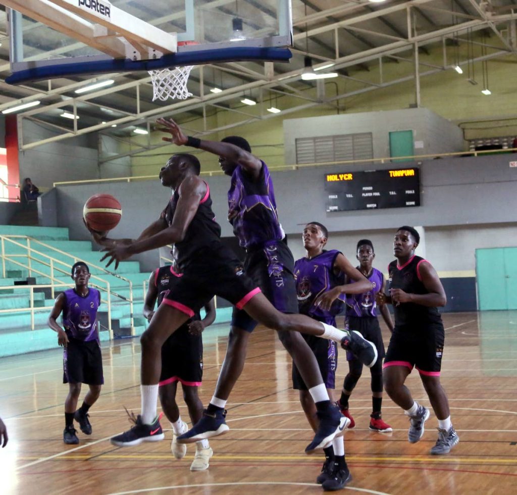 Jadon Samuel of Tunapuna Tigers goes for a reverse layup against Holy Cross College in the U-20 final of the East Zone Secondary Schools Basketball League yesterday at the Maloney Indoor Sports Arena.  