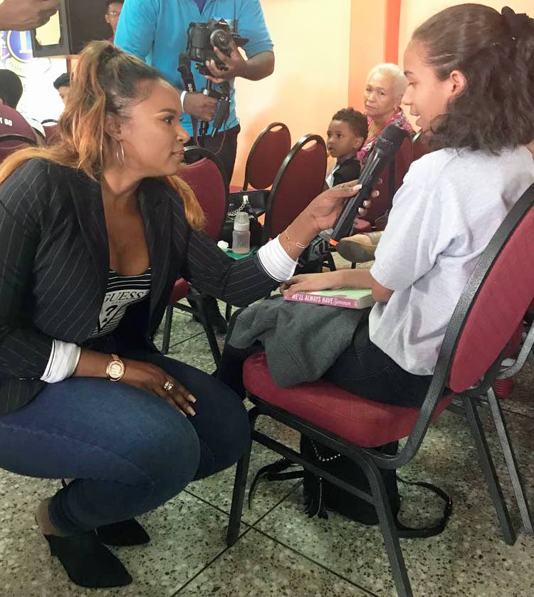 HEALTH TALK: Patron of the Diabetes Association, Nicole Dyer-Griffith, kneels to interact with a young member of the audience at the association's one-day camp yesterday at the Central Regional Indoor Sports Arena in Chaguanas. PHOTO COURTESY CARLA RAPHAEL