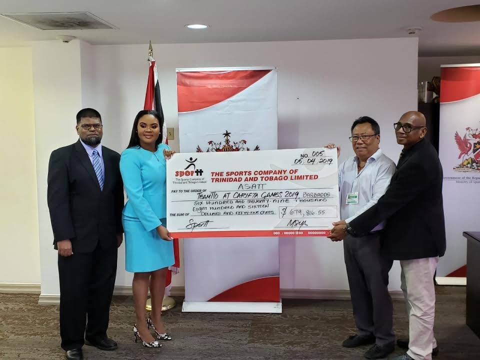 From left to right, permanent secretary at the Ministry of Sport, Farouk Hosein, and minister of sport Shamfa Cudjoe, present a dummy cheque to Lindsay Gillette, president of the Amateur Swimming Association of TT, and Anthony Creed, executive manager at SporTT. Photo courtesy Ministry of Sport. 