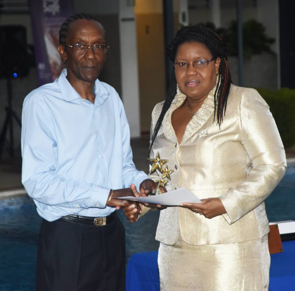 Andy St John presents principal of the Arouca Anglican Primary School Sharon Morian, with an award and cheque for her school, at the launch of the Adrian St John Foundation, on Wednesday, at the British High Commission, St Clair. 