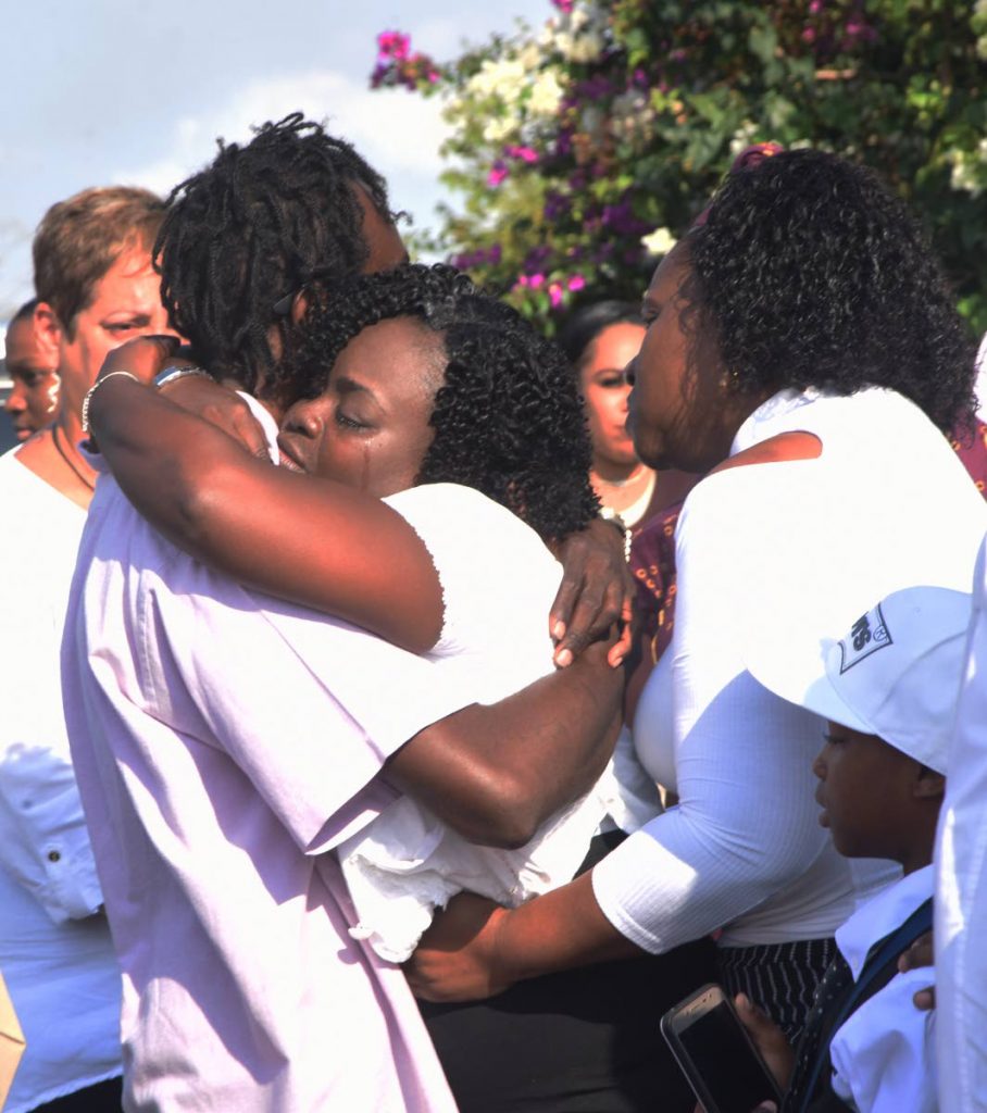 Family and friends comfort the mother of Akil Phillips, Joezal Vaughans, centre, during the teen's funeral at Our Lady of Laventille RC Church, in Laventille on Friday. PHOTO BY KERWIN PIERRE.