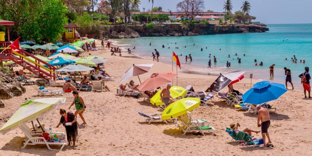Tourists and locals enjoy a day at Store Bay earlier this year. Hotel occupancy rates in the island are said to be lower than normal. FILE PHOTO