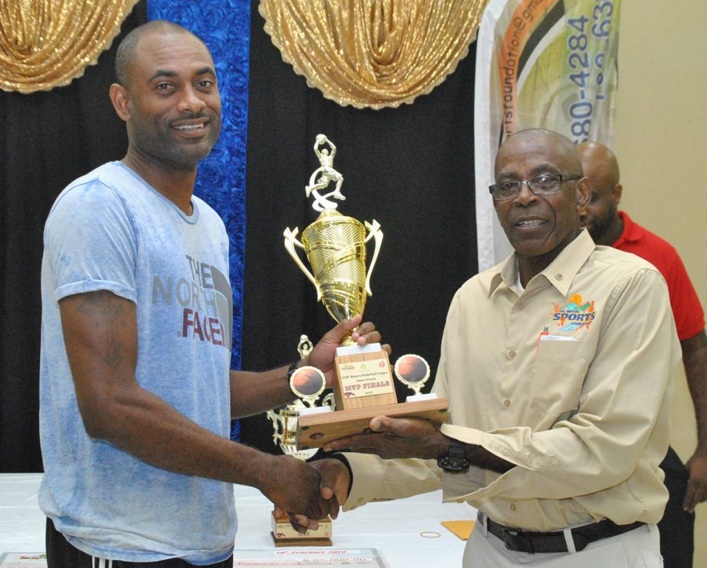 Stephen “Lighter” Lewis (left), of Matthew Pierre Basketball Academy, receives his MVP (Final) Senior Division trophy from AMSF’s President Bartholomew Lynch.