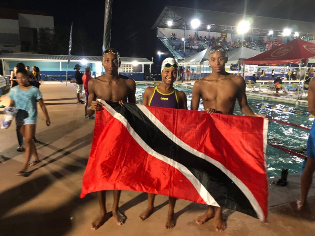 (From left) TT swimmers Nikolli Blackman, Jada Chatoor, and Zarek Wilson celebrate their wins yesterday, at the 34th Carifta Swimming Championship, held at the Barbados Aquatic Centre, Wildey, Barbados.