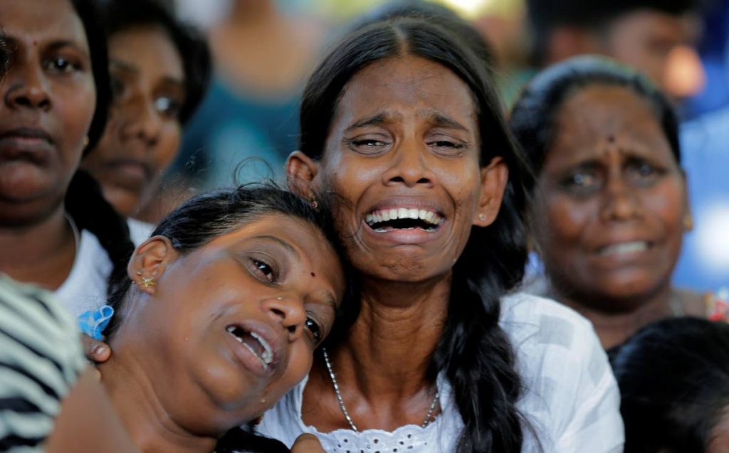 SORROW IN SRI LANKA: Relatives weep during a funeral for family members killed in the Easter Sunday bombings in Colombo, Sri Lanka. 