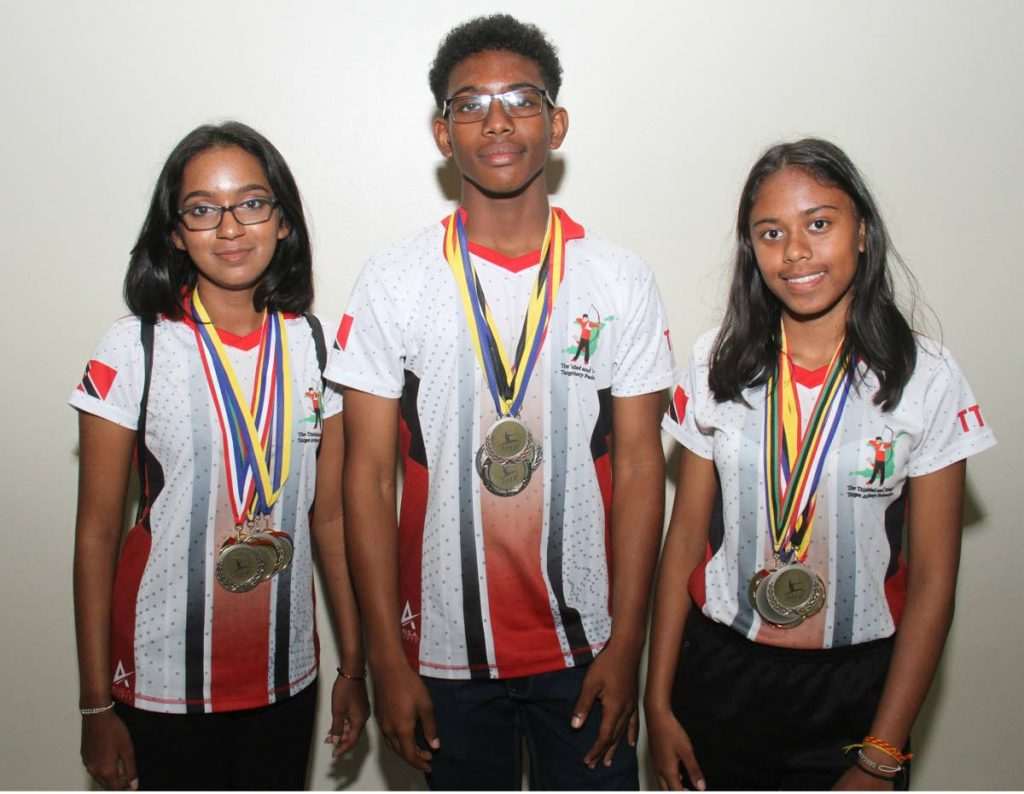 Members of the TT archery team Bryanna Ramlakhan,left, Darnell Garcia and Shanta  Roopchand, right, display their medals, on Tuesday night, at the Piarco Airport, after taking part in the Sourthern Caribbean Championships, held in Guadeloupe recently.