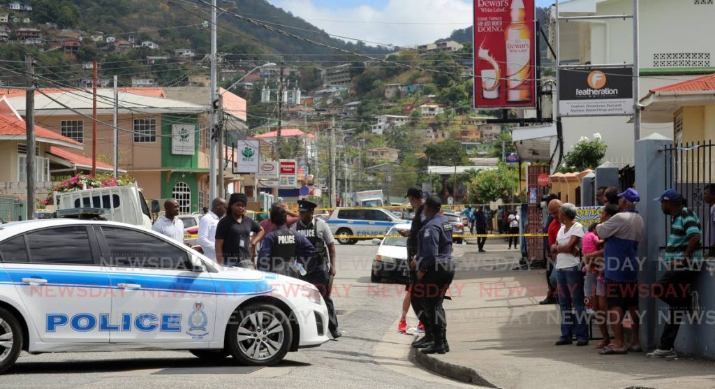 Police outside the liquor mart in St James where police are investigating an alleged attempted robbery which resulted in the death of a teenager. Photo by Sureash Cholai 