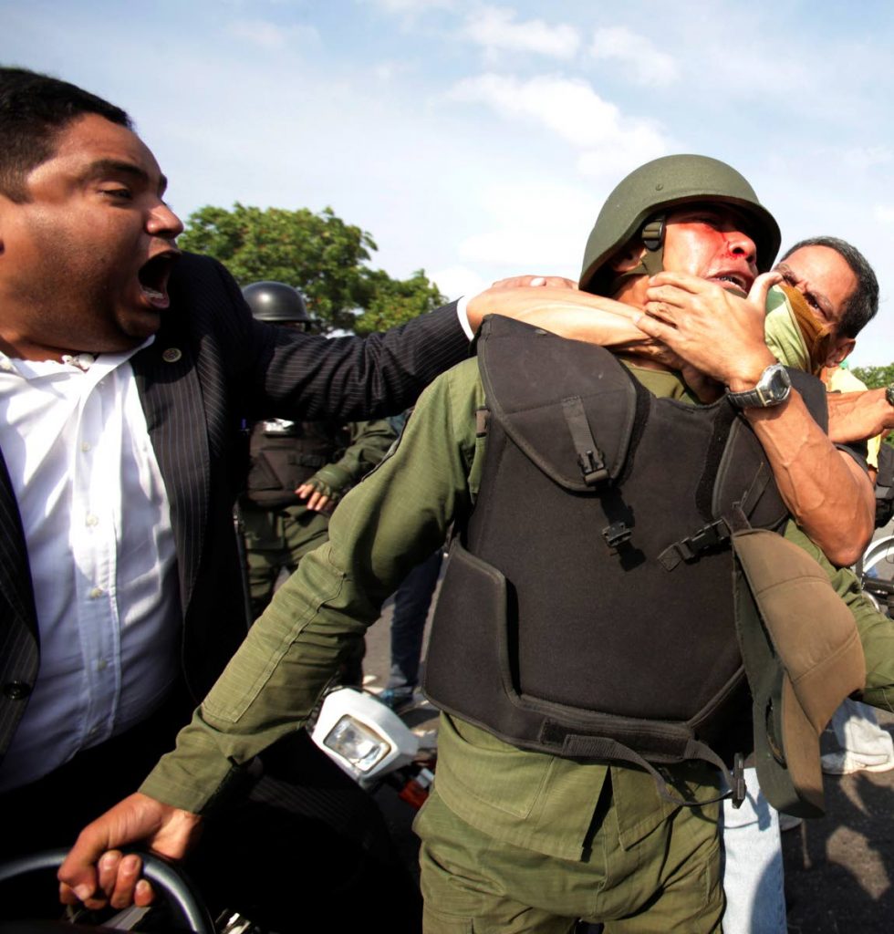 MAIN PHOTO ON PAGE 3

VIOLENCE: Anti-Maduro supporters attack a Bolivarian National Guard officer loyal to Venezuela President Nicolas Maduro during clashes yesterday in Caracas. 