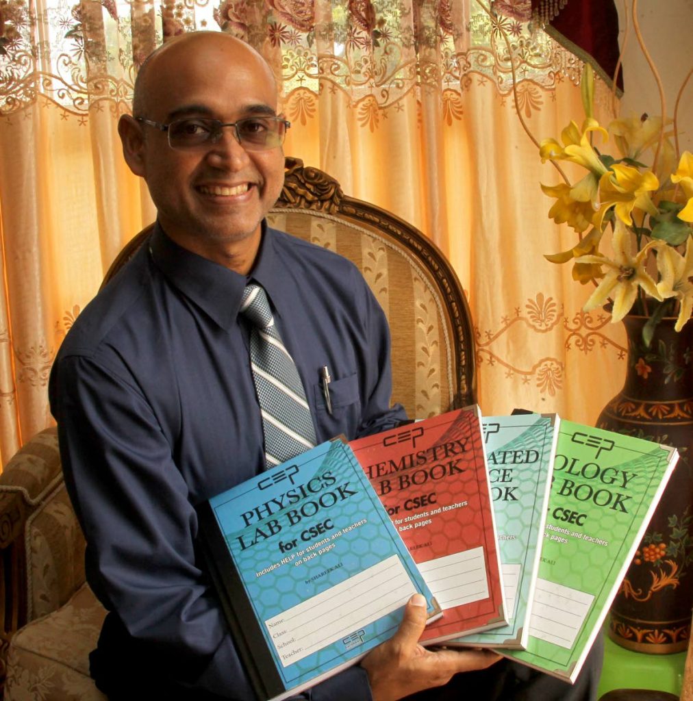ASJA Boys' College teacher Shareek Ali with SBA lab books for science subjects which he wrote to help students. PHOTOS BY ROGER JACOB