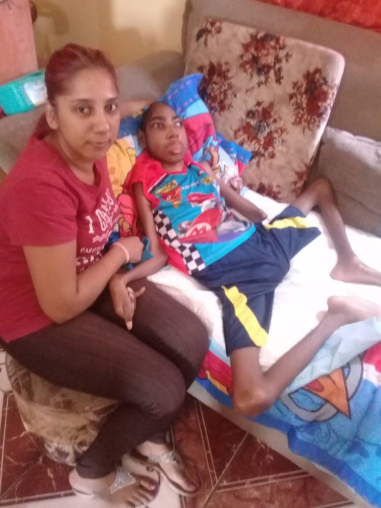 WE NEED HELP: Stacey Mootoo with her son Adam at their home in San Juan. PHOTO BY MARLENE AUGUSTINE