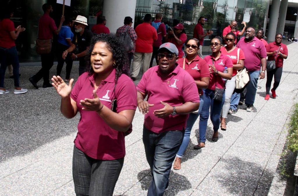 TEACHERS MARCH: Teachers march outside the Education Ministry in Port of Spain yesterday demanding an upgrade to their employment status. 