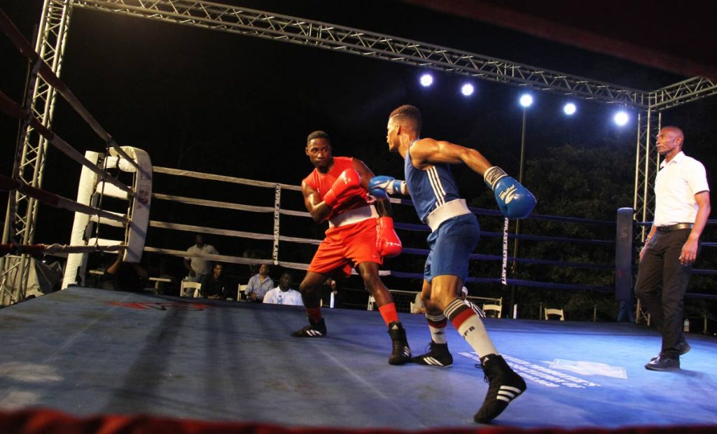 Michael Alexander, centre, on the attack against Aaron Prince at Boxing at the Castle at Brian Lara's residence, Brian Lara Drive, Port of Spain, on Thursday night. 