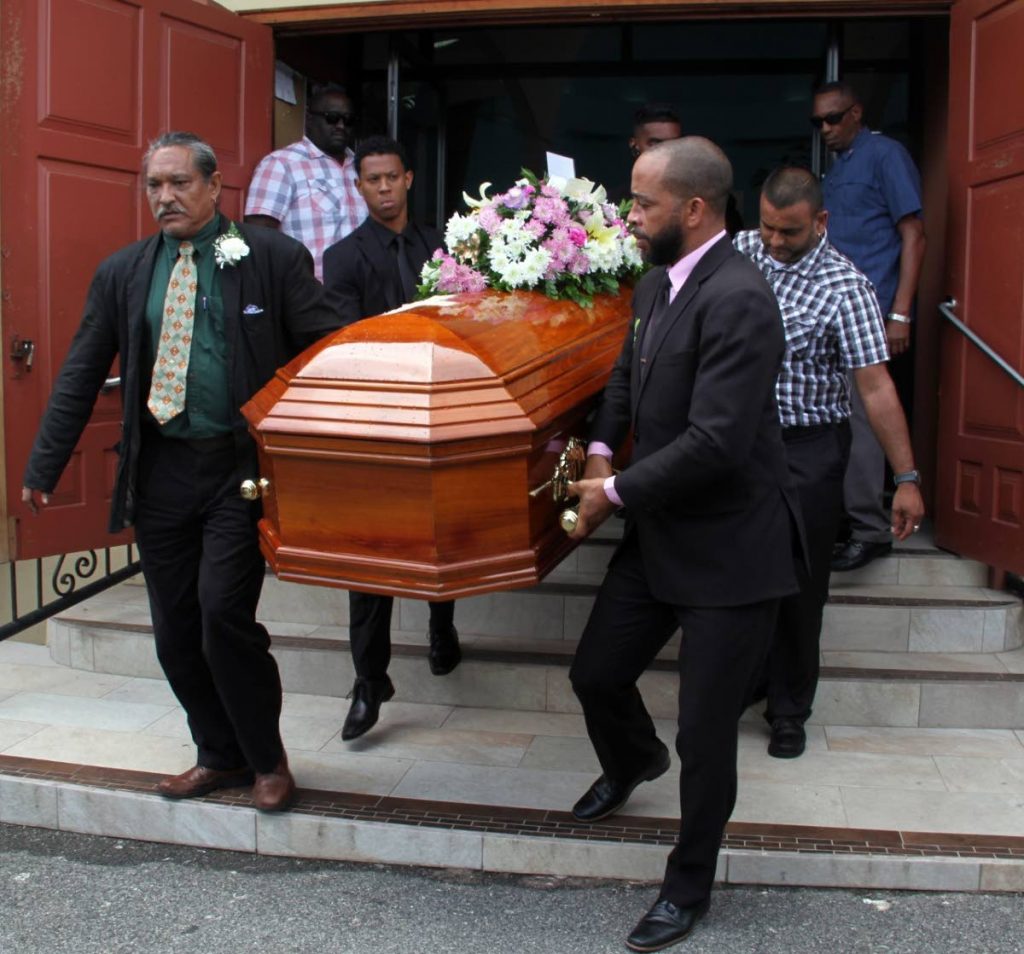 LAST RITES: Mourners with one of the coffins yesterday at St Benedict RC Church in La Romaine after the funeral for a family of three who was murdered last Monday along the Solomon Hochoy Highway. PHOTO BY VASHTI SINGH 