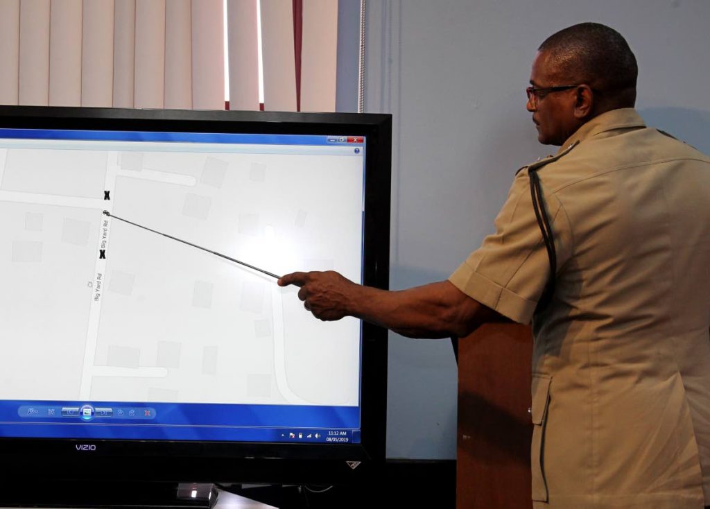 ASP Michael Pierre shows what police say was the position of the police car in relation to slain teenager Naomi Nelson during a shooting incident in Big Yard, Carenage, last Friday at the weekly police media briefing yesterday.